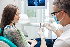 a dentist explaining how dental implants work in Powell