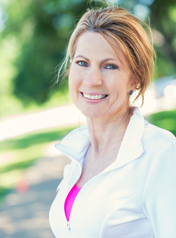 Woman with beautiful smile after replacing missing teeth with dental implants