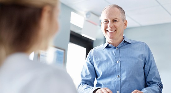 Man smiling at dental team member