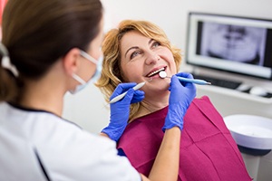 smiling woman being examined by a dentist