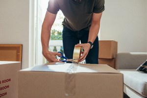 Closeup of person using scissors to cut tape