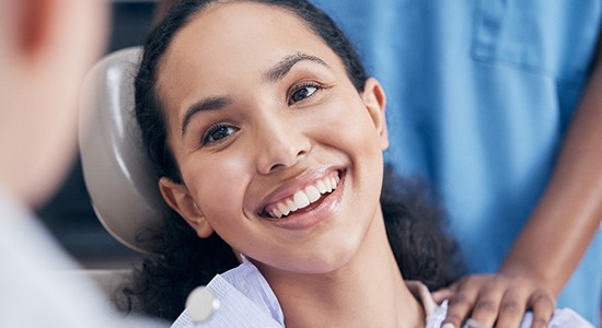a patient smiling while visiting her dentist