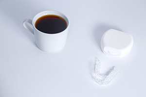 Invisalign next to a cup of coffee