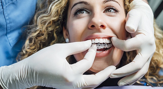 Dentist checking fit of patient's Invisalign tray
