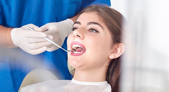 Woman receiving dental checkup and teeth cleaning