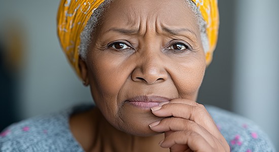 Concerned older woman touching her mouth