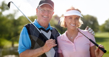 Older couple smiling after restorative dentistry treatment