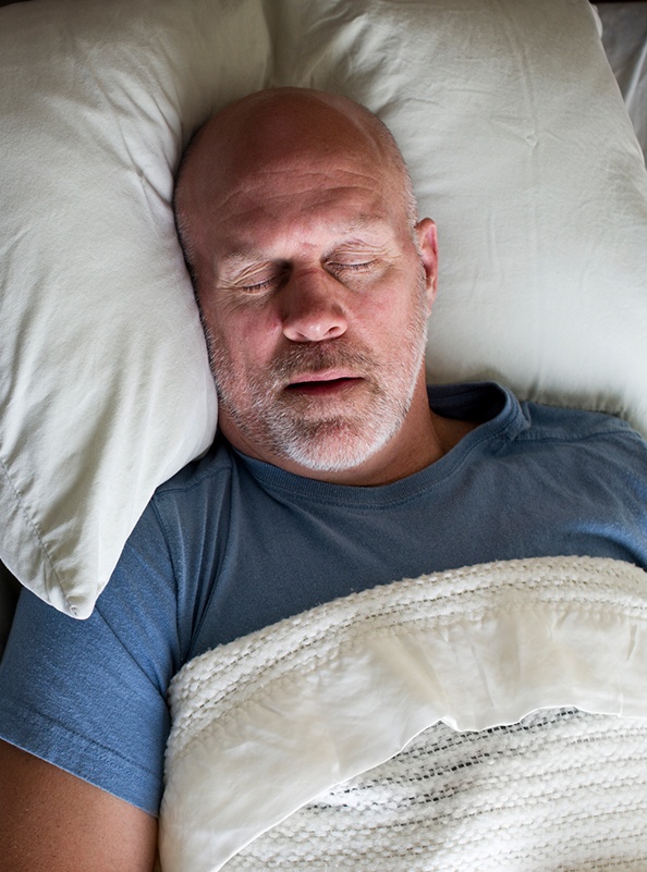 Man sleeping soundly thanks to sleep apnea therapy