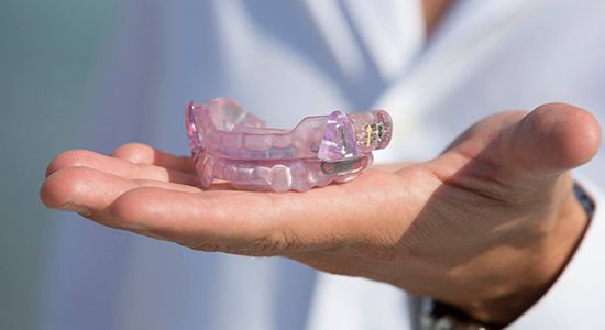 Hand holding a sleep apnea oral appliance