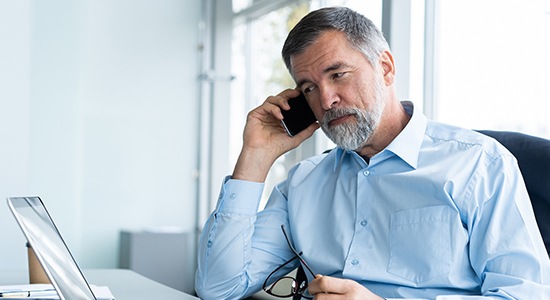 Man calling the dentist to learn more about sleep apnea treatment