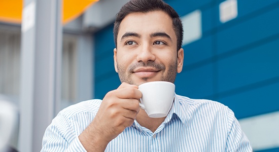 Man drinking coffee which causes dental stanining