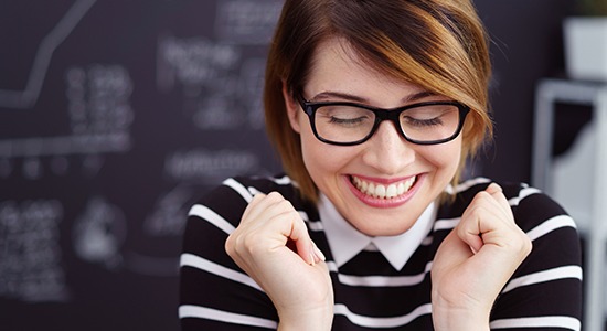 woman showing off flawless smile after porcelain veneer treatment