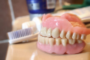 Dentures and toothbrush on counter