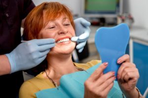 A woman viewing her new dental implants.