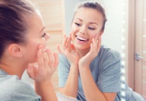 woman looking at smile in mirror