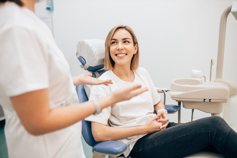 person smiling while talking to dentist